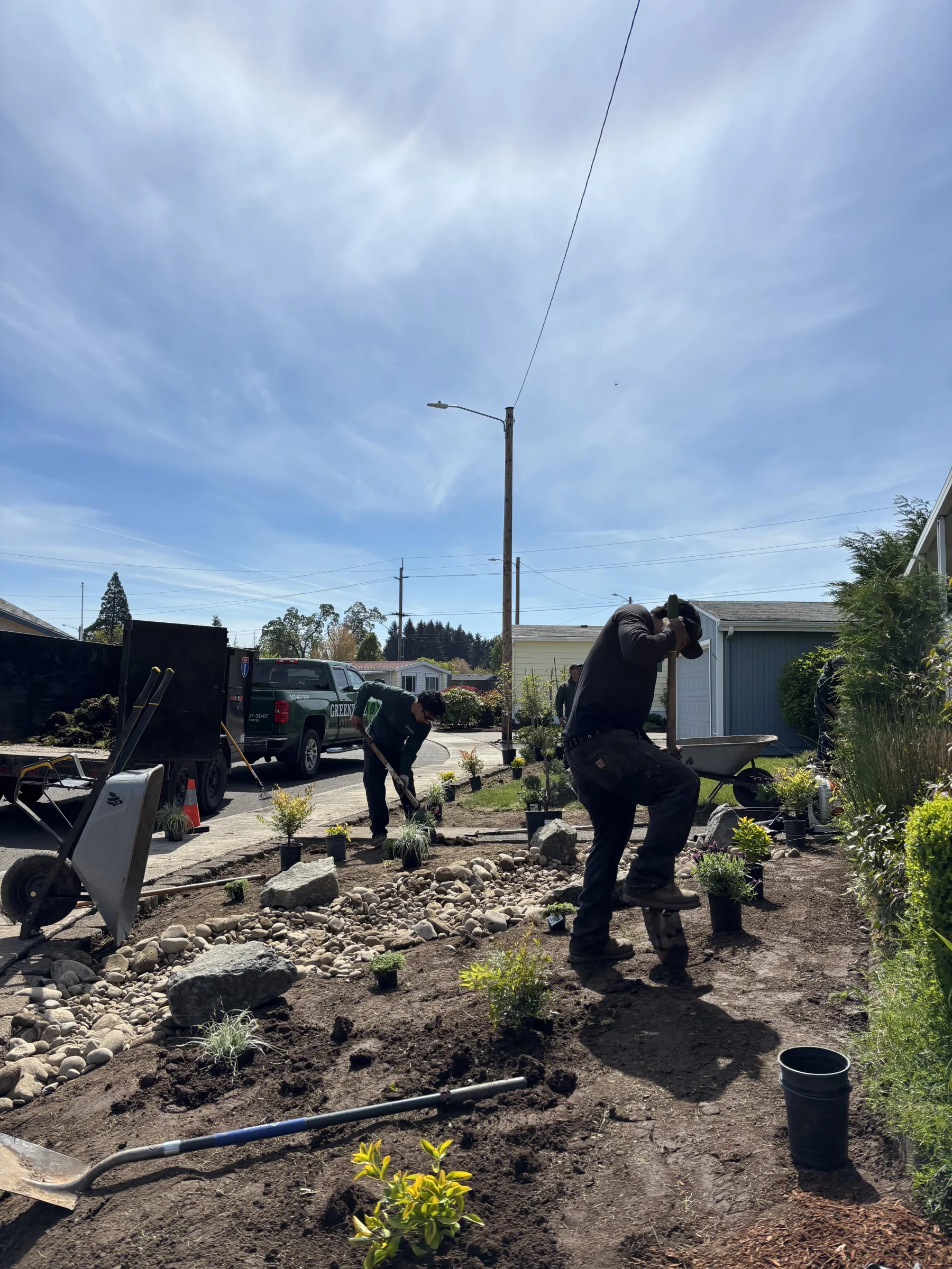 Professional landscape bed installation beside a commercial walkway